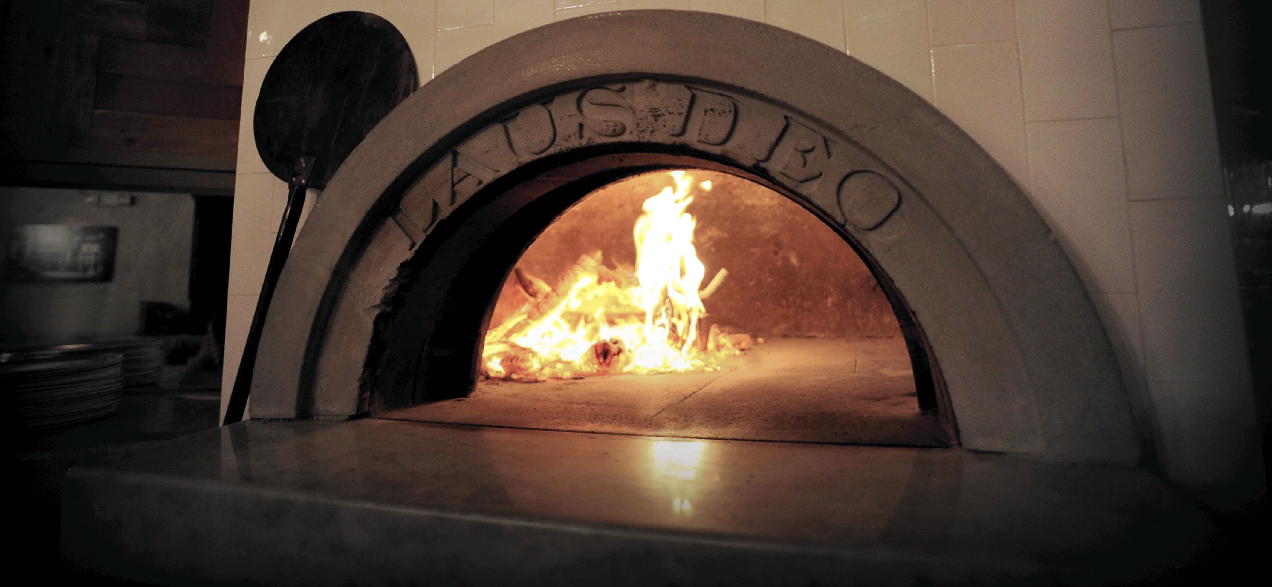 Brick oven pizza being prepared at Apizza Brooklyn